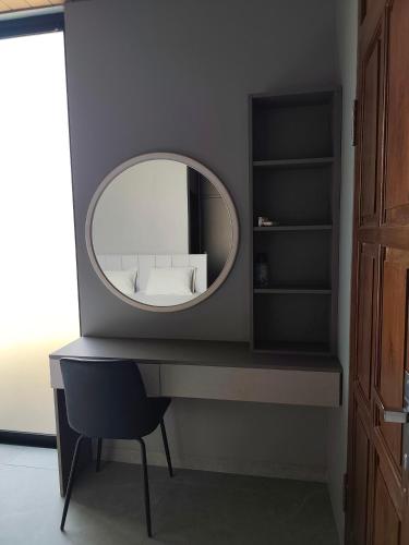 a dressing table with a mirror and a chair at Sonne Villa in Pangandaran