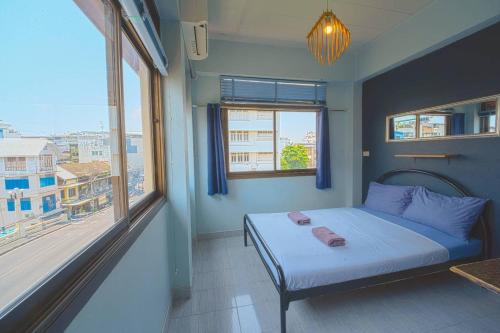 a bedroom with a bed and a large window at Mam's House Khaosan in Bangkok