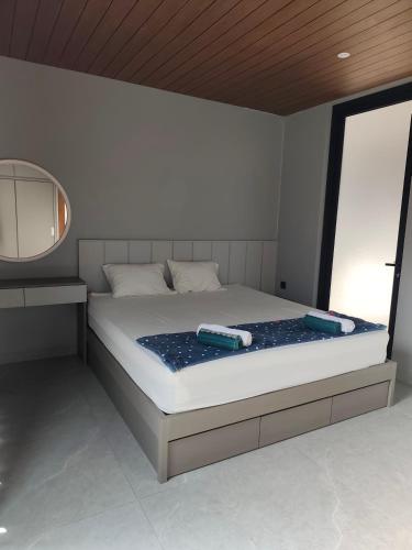 a bedroom with a large bed with a mirror at Sonne Villa in Pangandaran