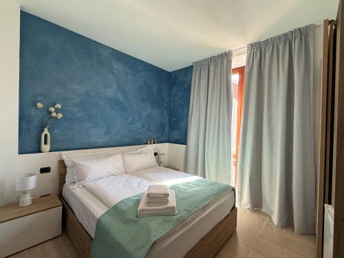 a bedroom with a bed with a blue wall at Holmann Haus in Olbia