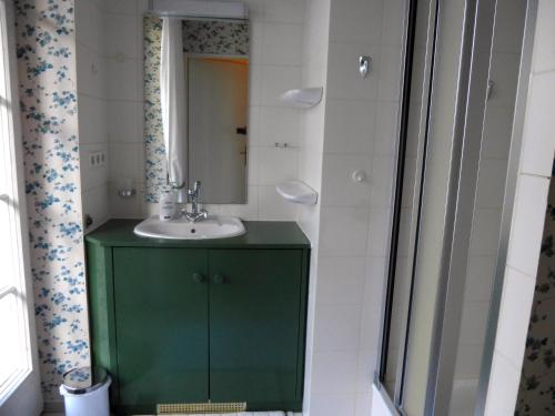 a bathroom with a green cabinet and a sink at Villa Kükenkamp in Rätzlingen