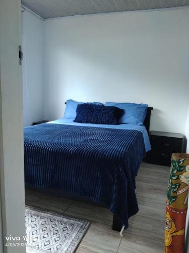 a bedroom with a bed with a blue comforter at Apartamento completo Santa Rosa de Cabal in Santa Rosa de Cabal