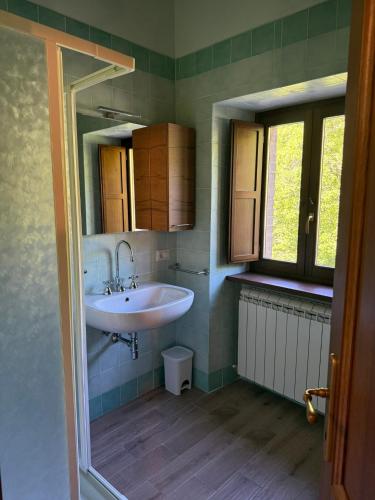 a bathroom with a white sink and a window at Castello di Acera in Campello sul Clitunno