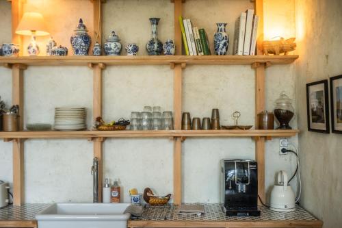 a kitchen with wooden shelves with blue and white vases at Château de Sainte-Sévère in Sainte-Sévère-sur-Indre