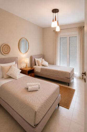 a bedroom with two beds and a window at Erofili's Apartment ONLY 700 meters from the beach in Ialysos