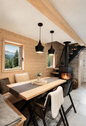 a dining room with a table and a fireplace at Chalet Velika Planina with Sauna - I FEEL ALPS in Stahovica