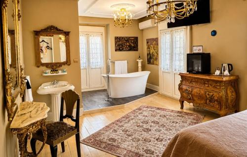 a bathroom with a tub and a sink and a bath tub at Hostal Boutique Puerta del Sol in Torrelavega
