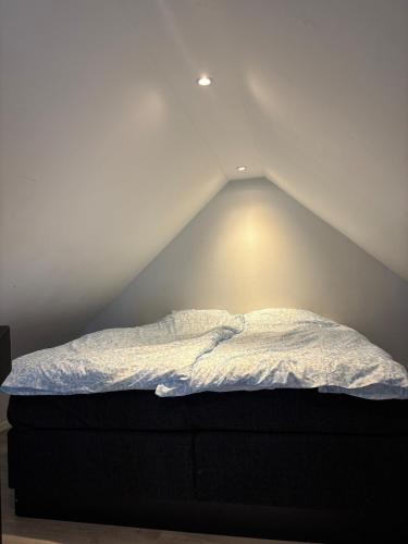 a bed in a room with a roof at Mysigt litet hus in Näsum