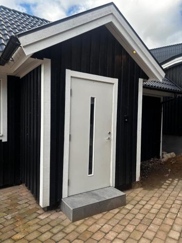 a black and white garage with a white door at Mysigt litet hus in Näsum