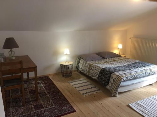 a bedroom with a bed and a table and two lamps at Gîte de la Buissonniere in Grand-Failly