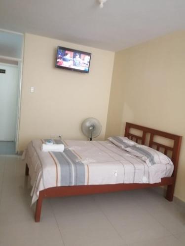 a bedroom with a bed with a lamp on the wall at Hospedaje San Valentin in Capitan Concha