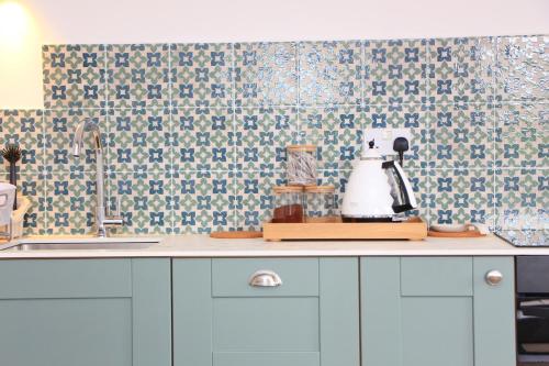 a kitchen with blue and white tiles on the wall at Attractive barn conversion near Padstow in Saint Merryn