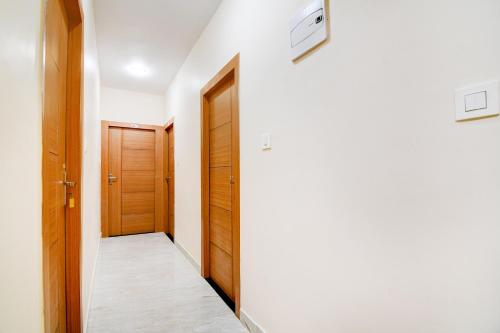 a hallway with two wooden doors and a floor at Hotel O by OYO Eco Greenway Retreat in Salua