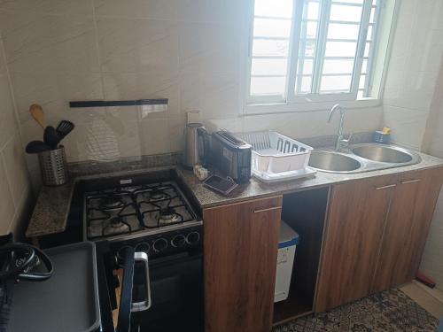 a small kitchen with a stove and a sink at Les Sublimes Residences Tweens in Abidjan