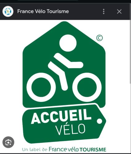 a green sign with a person riding a bike at La Villa Bleue in Beauchastel