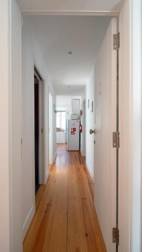 a hallway with white walls and a wooden floor at Apartamentos Aurea - Sesimbra in Sesimbra