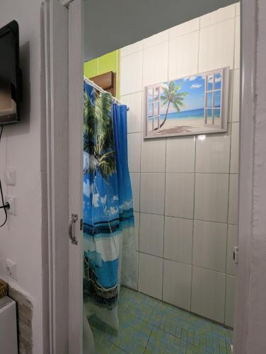 a bathroom with a shower with a picture of a palm tree at Angel Room 1 in Nea Plagia
