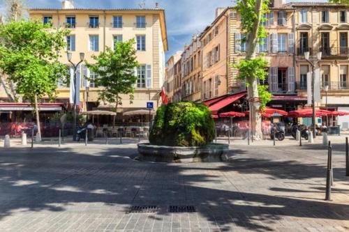 a city square with a fountain in the middle at Duplex Mirabeau - Hyper center city - Calm in Aix-en-Provence