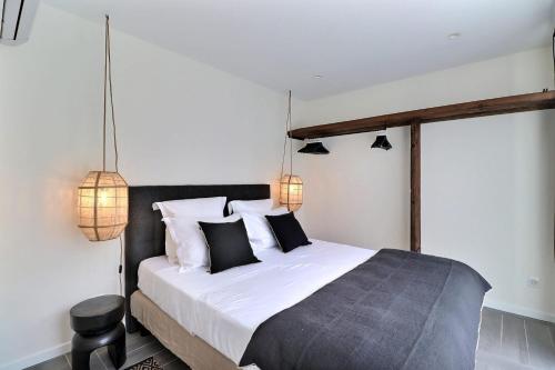 a bedroom with a bed with black and white pillows at La Cabane du Cap - Jacuzzi & City Center Nearby in Aix-en-Provence