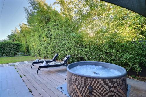 a hot tub on a wooden deck with two chairs at La Cabane du Cap - Jacuzzi & City Center Nearby in Aix-en-Provence