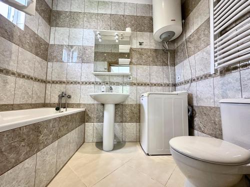 a bathroom with a sink and a toilet and a tub at Anit Rooms in Luštica