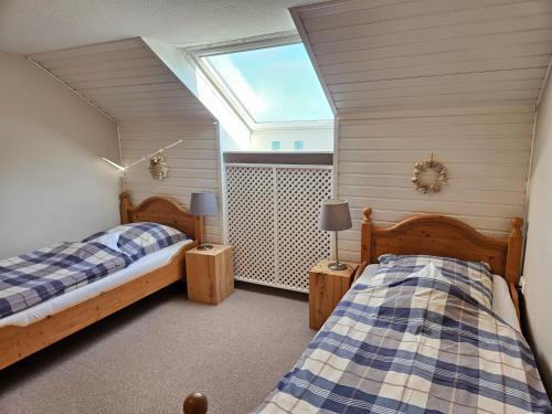 two twin beds in a room with a window at Hof Muhs in Stakendorf