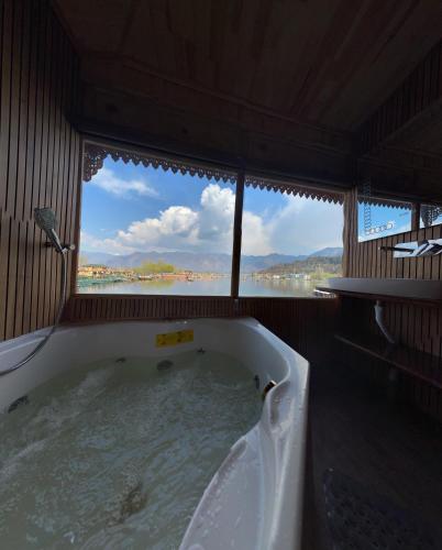 a bath tub with a view of the water at Smith Palace Group Of Houseboats in Srinagar