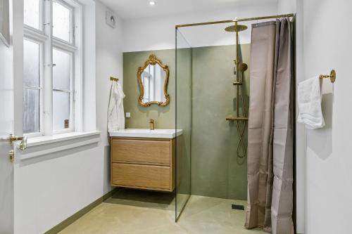 a bathroom with a sink and a shower at Det gamle Apotek Møn in Stege