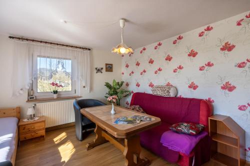 a living room with a purple couch and a table at FeWo Spreequelle in Herrnhut