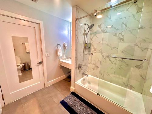 a bathroom with a shower with a glass door at The Chic Suite - 1BR with Luxe Amenities in Paterson
