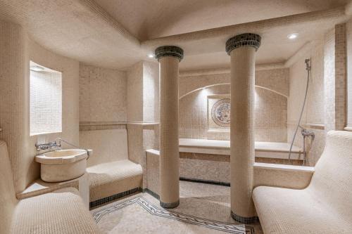 a bathroom with columns and a tub and a sink at Sonata Hotel in Kyiv