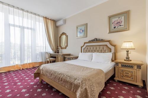 a hotel room with a bed and a desk and a window at Sonata Hotel in Kyiv