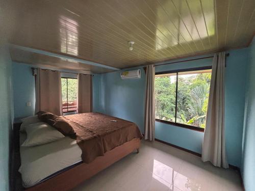 a bedroom with a bed and a large window at La Reina del Mar in Drake