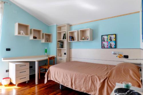 a bedroom with a bed and a desk and blue walls at La Casa di Gio - 2 Camere Singole in Campanella