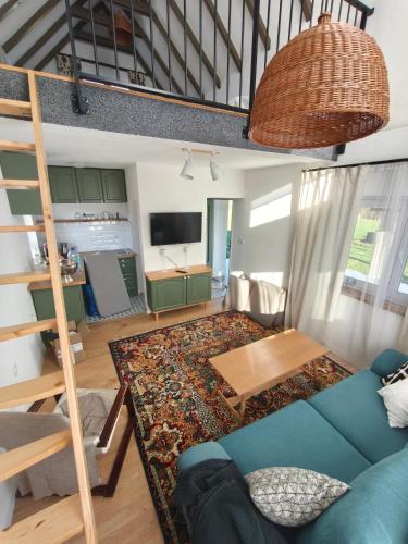 a living room with a blue couch and a table at Holiday Home Kostandinovic in Modriča