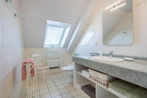 a bathroom with a sink and a toilet and a mirror at Chambres D'hôtes De Kerantum in Mahalon