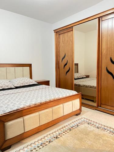 a bedroom with a bed and a mirror at Soleil, mer & douceur à Staoueli in Alger