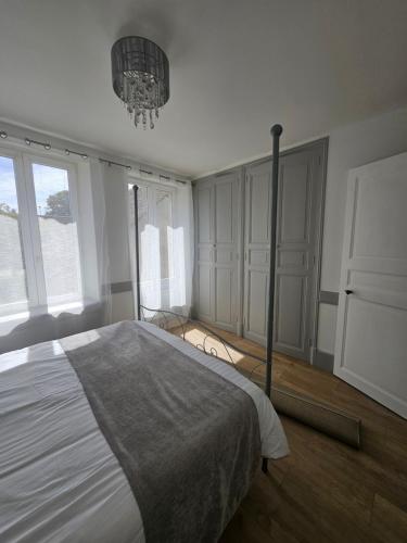 a bedroom with a large bed and a chandelier at Church View Apartments in Châteauneuf-Val-de-Bargis