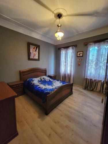 a bedroom with a bed with a blue comforter at Дом in Kobuleti