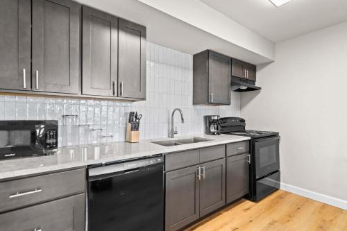 a kitchen with gray cabinets and black appliances at Newly Renovated Unit in Central Spfld #201 in Springfield