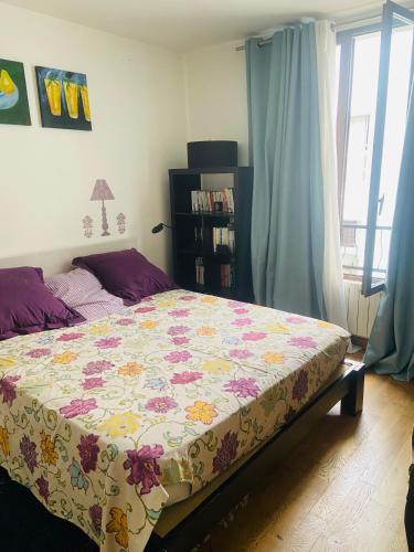 a bedroom with a bed with a floral bedspread at Les Marais 2 in Le Pré-Saint-Gervais