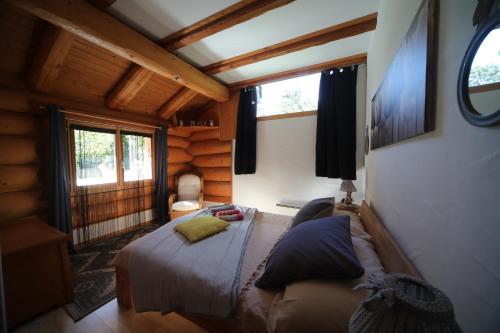 a bedroom with a bed in a log cabin at Le Gîte de Briey - Chalet complet in Chalais