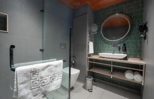 a bathroom with a sink and a toilet and a mirror at Weekend Retreat- Hotel & Spa in Kurseong