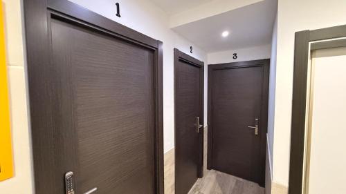 two brown doors in a room with a bathroom at Pension GAZTELUGATXE in Bermeo
