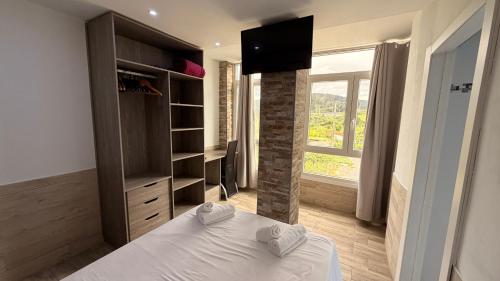 a bedroom with a bed and a television and a window at Pension GAZTELUGATXE in Bermeo