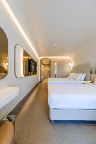 a bedroom with a large white bed and a sink at Altınorfoz Hotel in Ayaştürkmenli