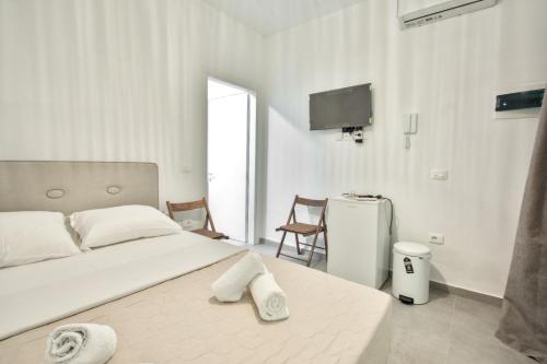 a white bedroom with a bed with towels on it at Southern Nights in Gjilek