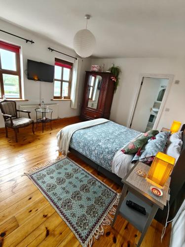 a bedroom with a large bed with a table and a table sidx sidx at Boherbui B&B in Doolin