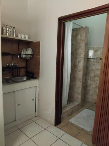 a bathroom with a shower and a sink at Slaapnet Guesthouse Long Stay Accommodation Wilkoppies in Klerksdorp