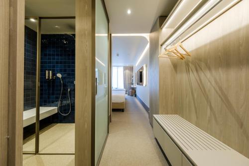 a bathroom with a walk in shower and a bench at Altınorfoz Hotel in Ayaştürkmenli